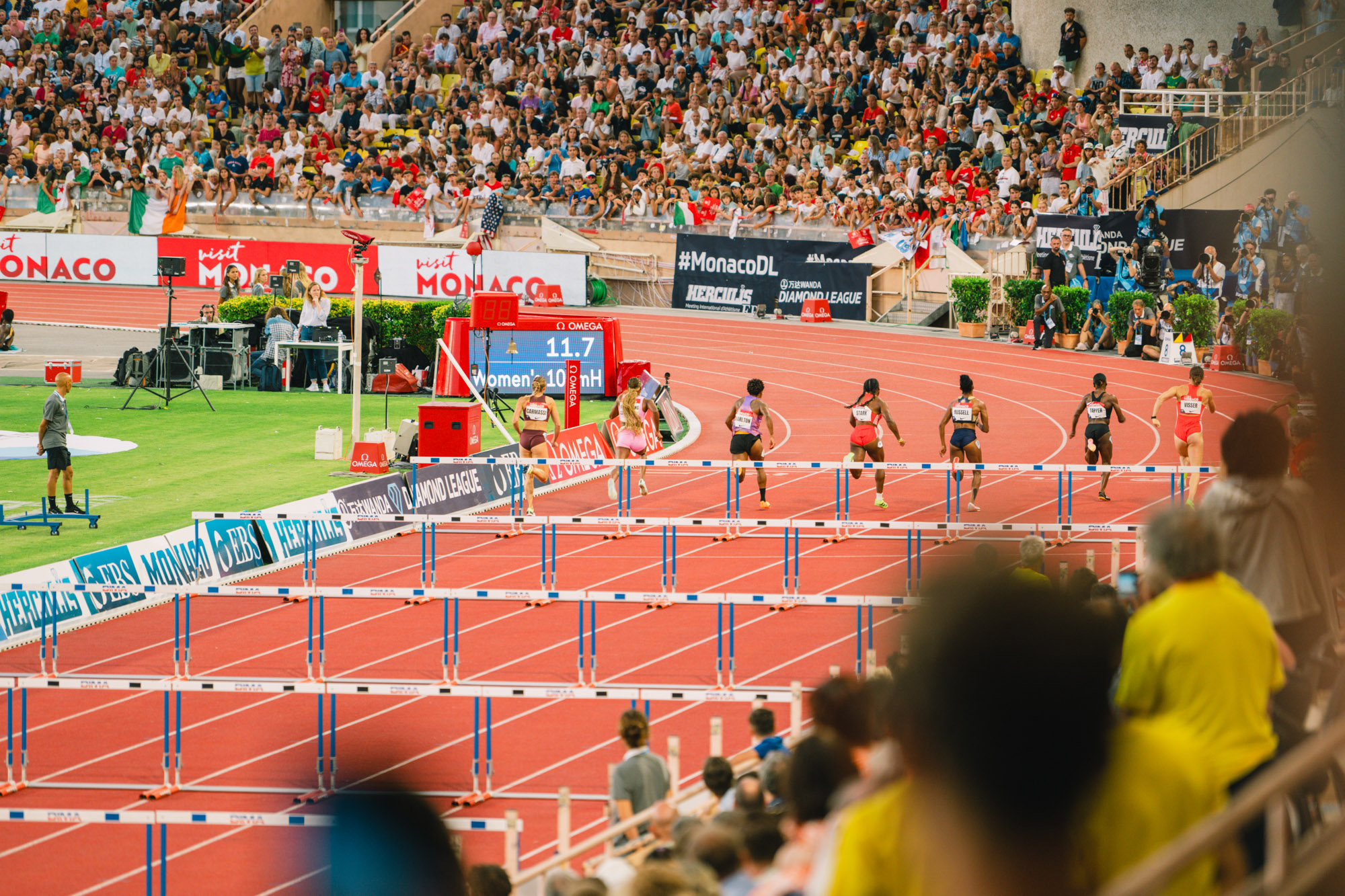 Photographe sportif capturant un athlète en pleine action lors d'un événement sportif