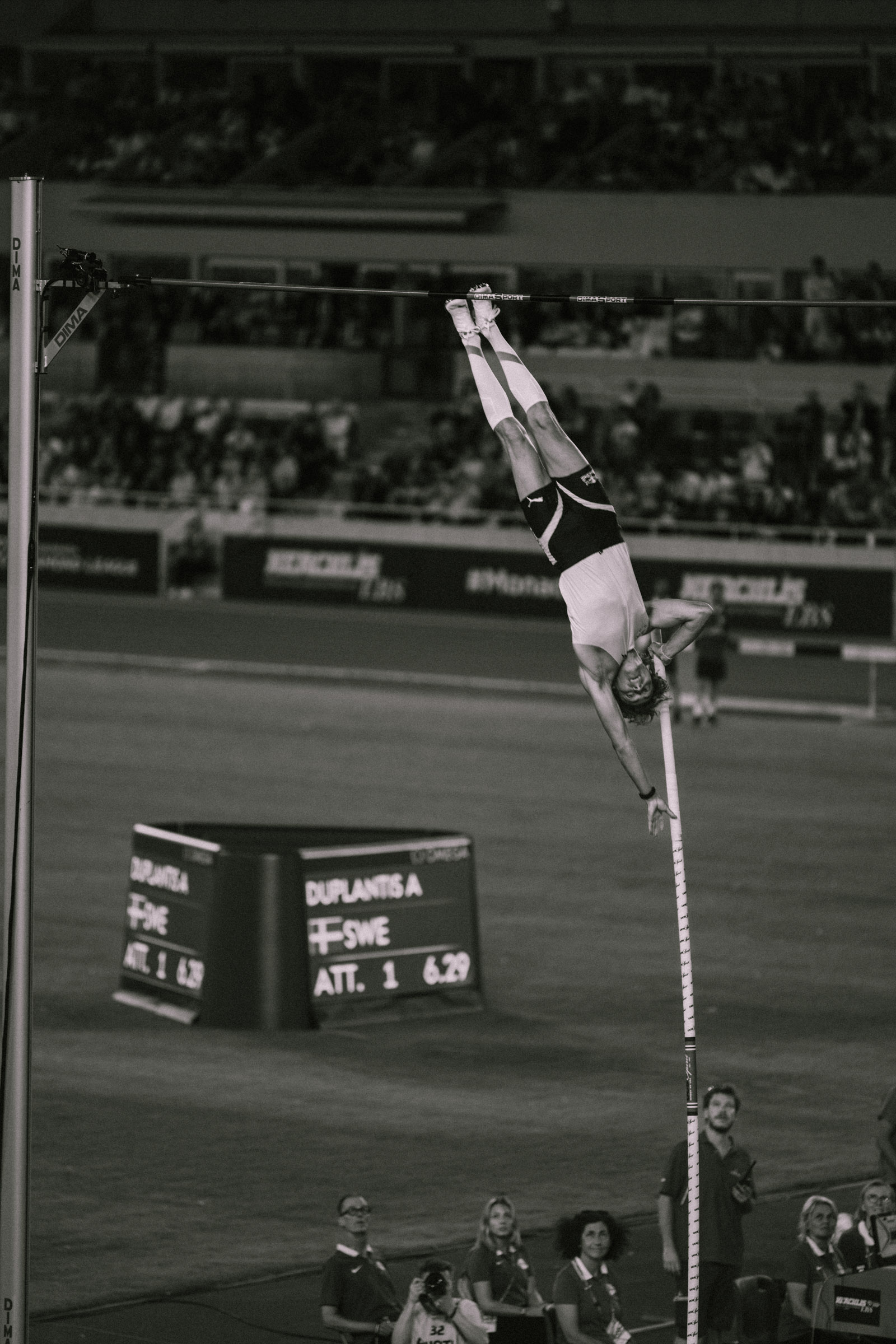 Photographe sportif capturant un athlète en pleine action lors d'un événement sportif